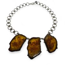 A Baltic amber statement necklace. Featuring three slices of clarified baltic amber claw set and