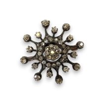 A Victorian diamond celestial brooch, featuring a central daisy cluster surrounded by star from