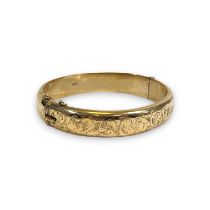 A 9ct gold hinged bangle, with foliate decoration. With safety chain. Gross weight approximately