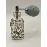 A solid silver and glass perfume bottle with flower for detail on front. 1920s art nouveau style.