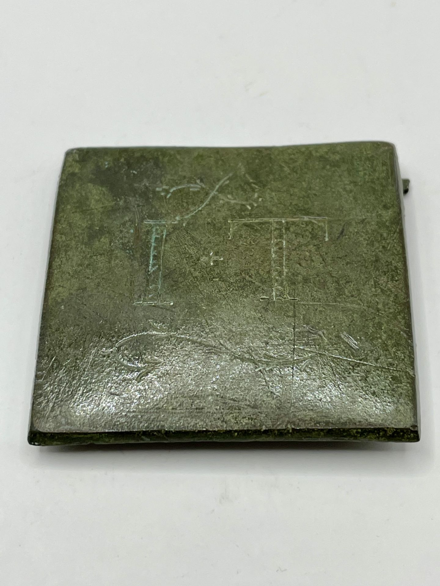 Roman Bronze Square leather Mount with the inscription I.T with floral design.