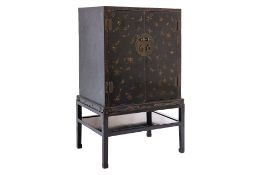 A LACQUERED BUTTERFLY CABINET ON STAND