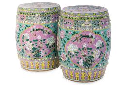 AN OPPOSING OR MIRRORED PAIR OF FAMILLE ROSE PORCELAIN DRUM STOOLS