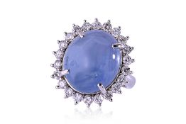 A CABOCHON BLUE STAR SAPPHIRE AND DIAMOND 'HALO' RING
