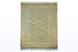 A SOFT-PILE WOOL RUG IN GREEN TONES (179 x 127cm)