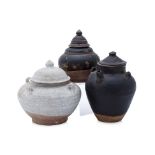 A GROUP OF THREE POTTERY JARS AND COVERS