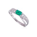 AN EMERALD AND DIAMOND CROSSOVER RING