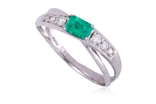 AN EMERALD AND DIAMOND CROSSOVER RING