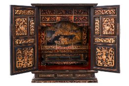 A HEAVILY CARVED AND PARCEL GILT ALTAR CABINET