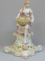 A German porcelain figure of a lady sat on a pedestal, 30.5cm