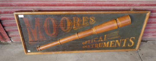 A pailnted wooden Moore's Optical Instrument Sign
