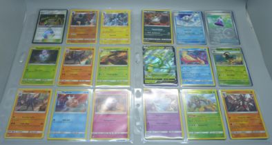 99 Holographic Pokemon cards from different sets, all in protective sleeves