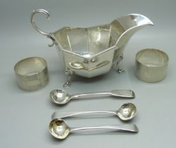 A silver sauce boat, two silver napkin rings, a pair of silver mustard spoons and one other silver