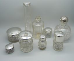 Nine silver topped glass bottles and jars