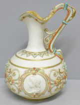 A late 19th Century ewer, decorated in blue, orange and gold against a cream ground with two