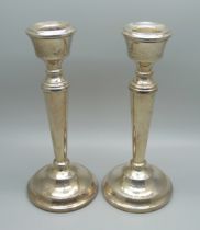 A pair of silver candlesticks with weighted bases, 15.5cm