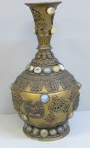 An embossed Tibetan brass vase set with thirty-nine cabochon stones, 24cm