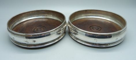 A pair of silver wine bottle coasters