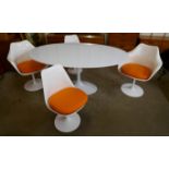 An Eero Saarinen style white laminate tulip oval dining table and four chairs