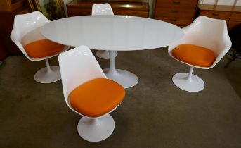An Eero Saarinen style white laminate tulip oval dining table and four chairs
