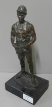 A bronze figure of a miner, on black marble socle
