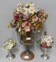 A brass and copper vase and a pair of smaller vases each with painted tin plate flowers
