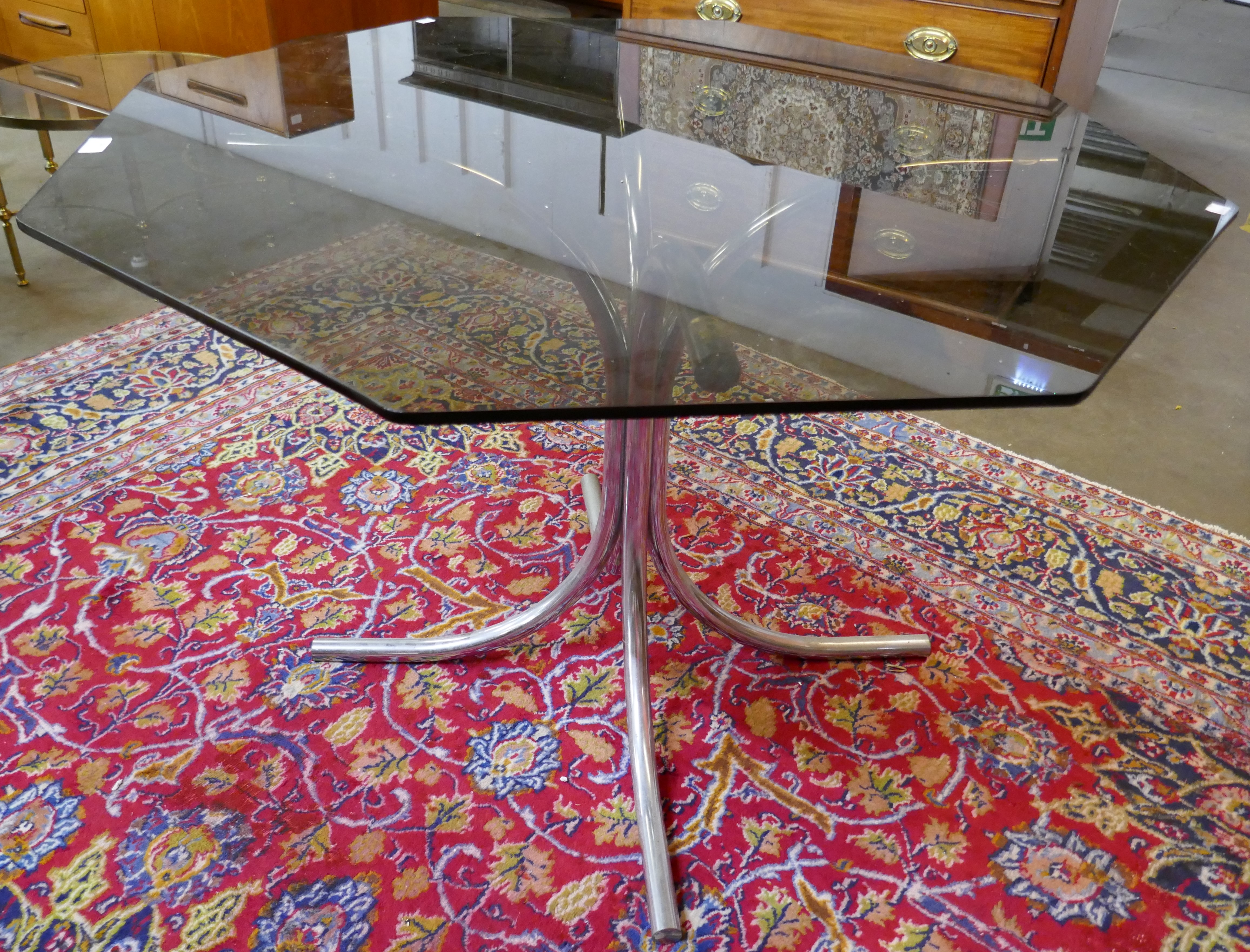 A chrome and hexagonal glass topped dining table