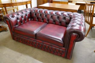 An oxblood red leather Chesterfield settee/bed