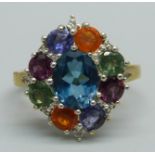 A silver gilt, multi gem cluster ring including topaz, apatite, iolite, garnet and fire opal, S