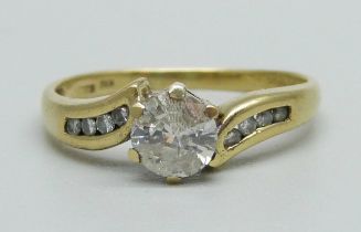 An 18ct gold and diamond solitaire ring with diamond shoulders, approximately 0.60ct diamond weight,