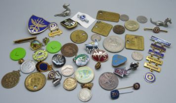 A collection of tokens, pin badges and coins