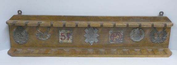 An oak pipe rack, 51st Highlanders with five applied badges