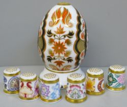 A Royal Crown Derby egg on stand, India and six Chatsworth thimbles