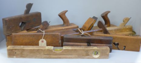 Seven woodworking planes and a level
