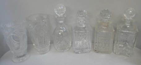 A collection of crystal cut glassware including decanters and vases
