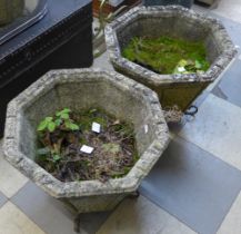 A pair of concrete garden planters on wrought steel stands