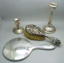 Two silver candlesticks, a silver backed mirror and a silver brush