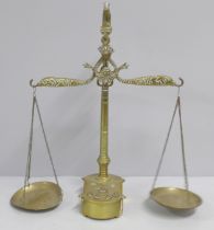 A set of brass balance scales and weights, two weights missing