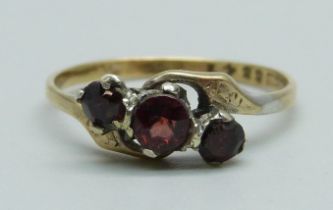 A 9ct gold and three stone garnet ring, 1.6g, Q, centre stone replaced