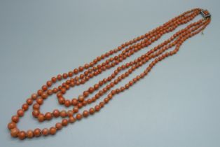 A vintage three strand coral necklace with pearl set yellow metal clasp, 62.4g