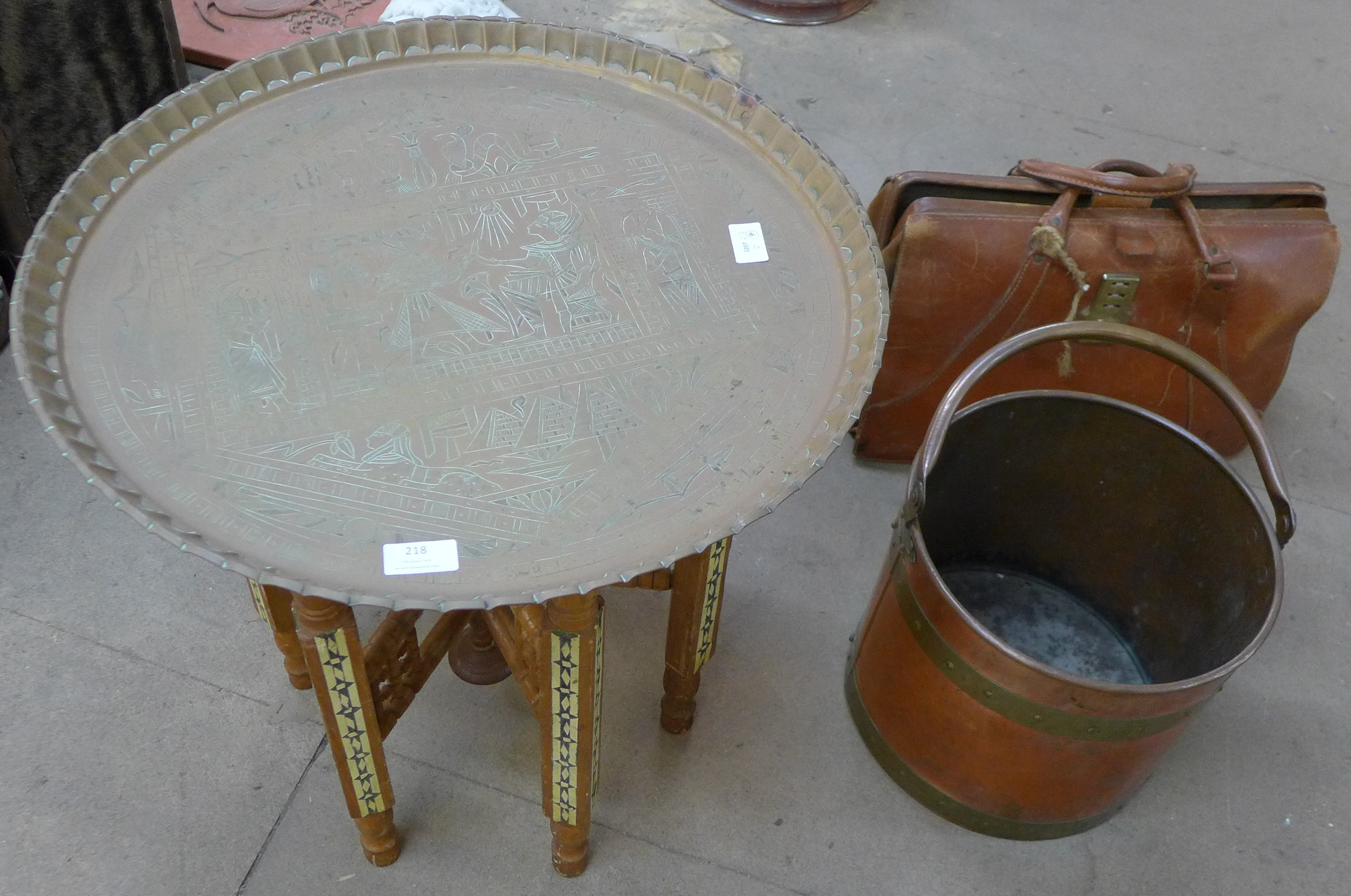 An Islamic brass topped occasional table, a copper and brass coal bucket and a leather Gladstone bag
