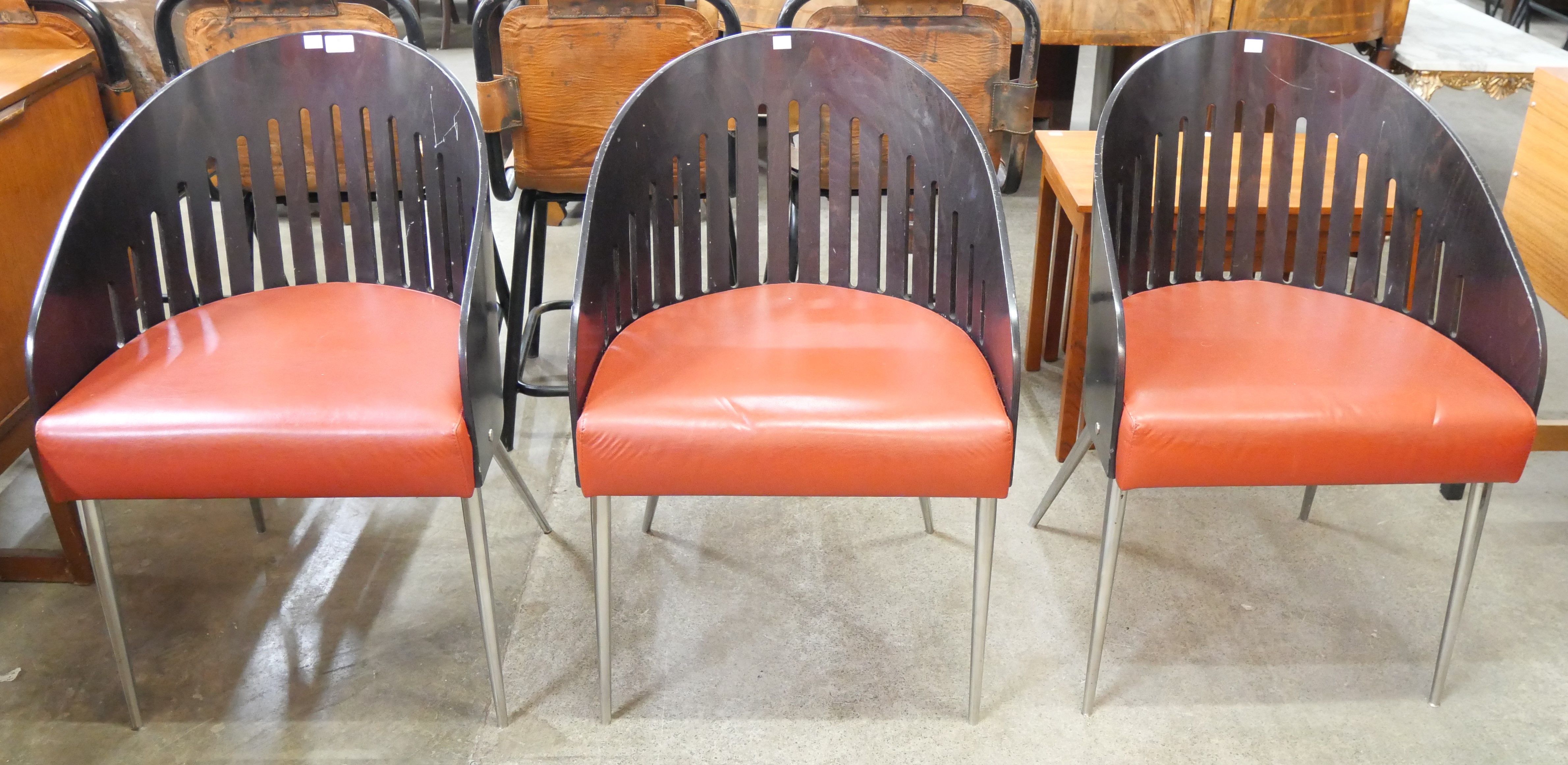 A set of three Phillipe Starck style bent plywood and red vinyl chairs