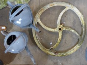 A cast iron wheel crank and two galvanised watering cans
