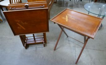 A set of four inlaid teak folding occasional tables on stand