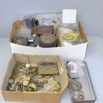 A collection of watch repair materials/horological parts including springs, balances