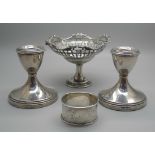 A pair of silver dwarf candlesticks, a silver pedestal bon-bon dish and a silver napkin ring, (