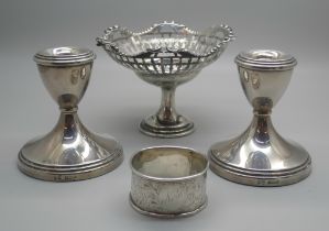 A pair of silver dwarf candlesticks, a silver pedestal bon-bon dish and a silver napkin ring, (