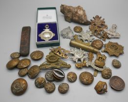 Military cap badges, a piece of schrapnel and a silver fob medal