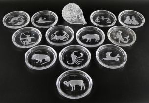 A set of twelve astrological star sign wine coasters by Val St Lambert, and a glass hedgehog, signed