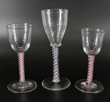 An 18th Century continental colour twist glass and two 19th Century red double twist glasses